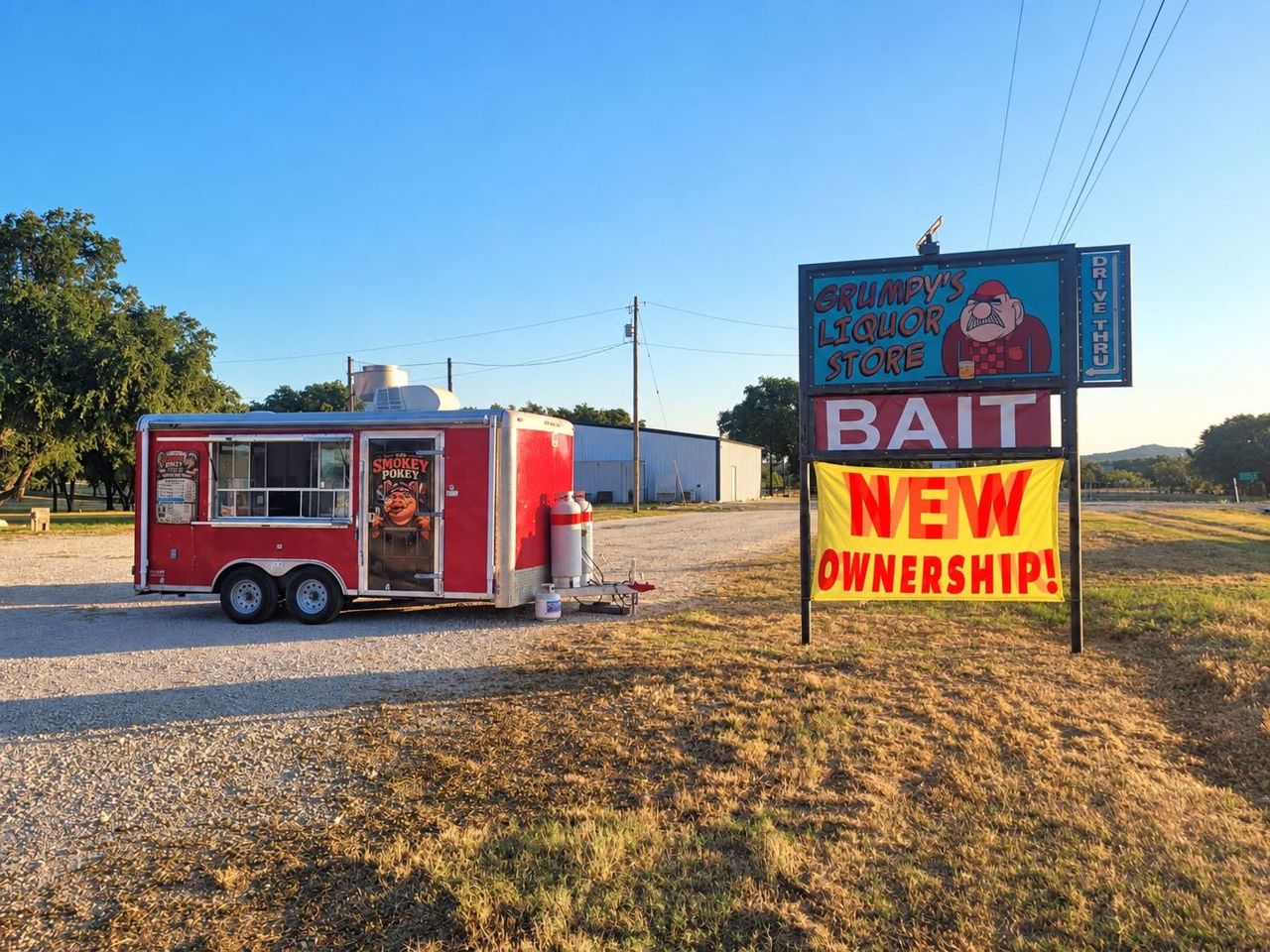 Gravel lot under a blue sky with a red food trailer and a roadside sign, from the Icehouse's Facebook page